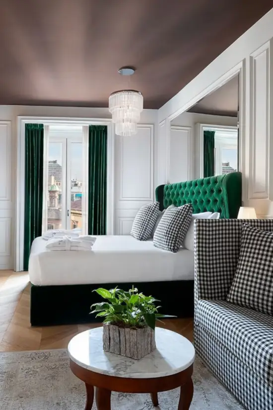 Dettaglio di uno dei letti delle camere dal Matilde Boutique Hotel, con struttura imbottita verde.