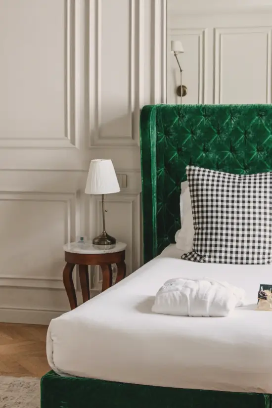 Dettaglio di uno dei letti delle camere dal Matilde Boutique Hotel, con struttura imbottita verde.