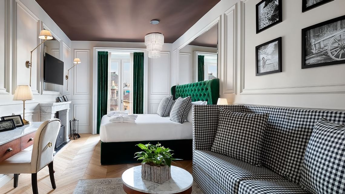 Foto dell'interno di una delle suite del Matilde Boutique Hotel, con divano, letto matrimoniale, TV e vista su Milano