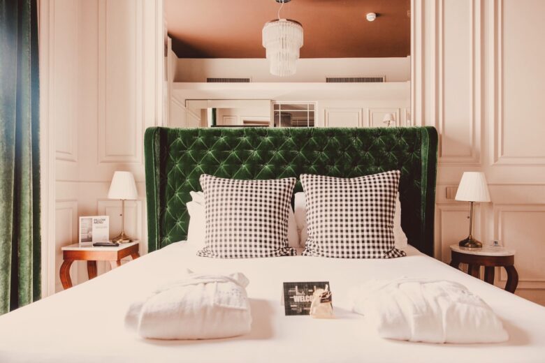 Dettaglio di uno dei letti delle camere dal Matilde Boutique Hotel, con struttura imbottita verde.