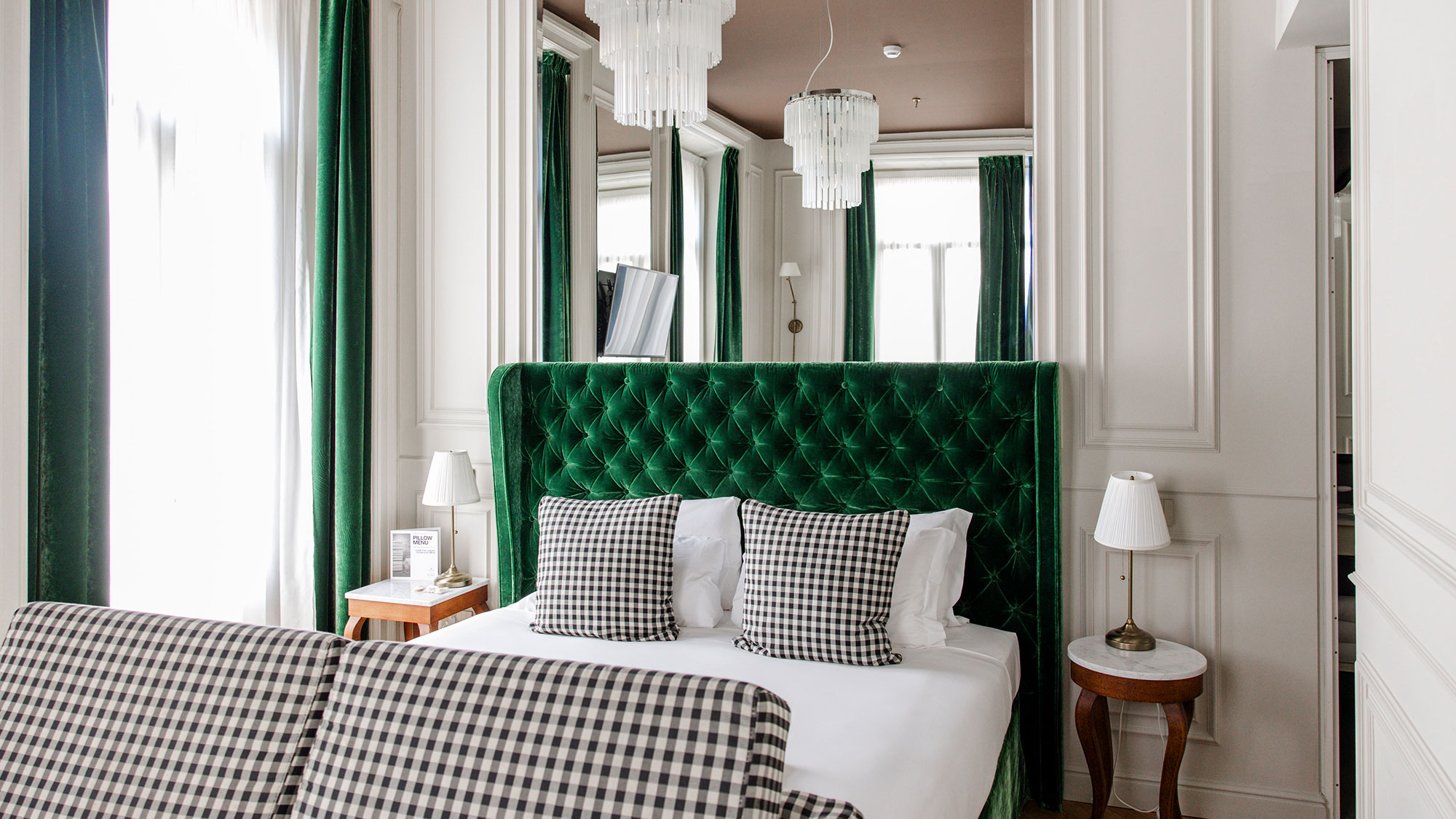 Dettaglio di uno dei letti delle camere dal Matilde Boutique Hotel, con struttura imbottita verde.