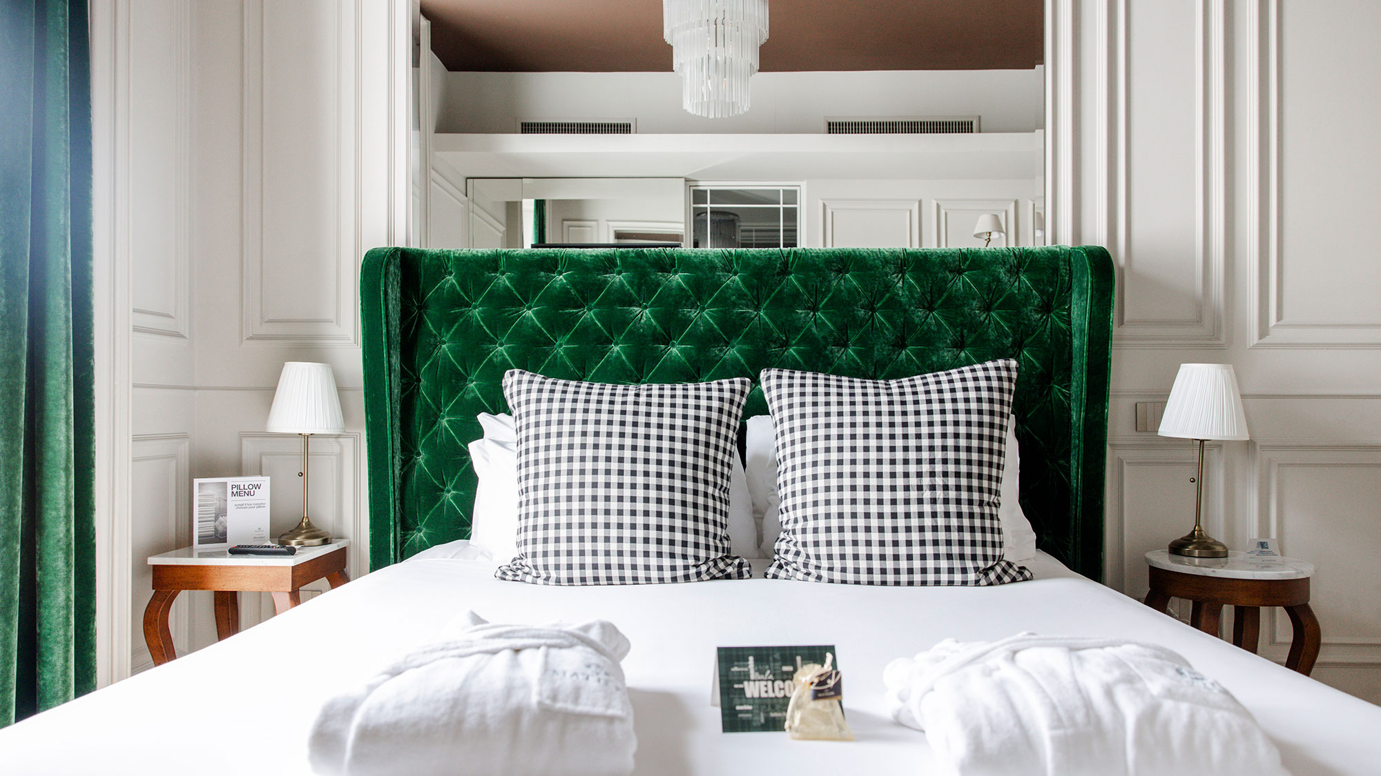 Dettaglio di uno dei letti delle camere dal Matilde Boutique Hotel, con struttura imbottita verde.