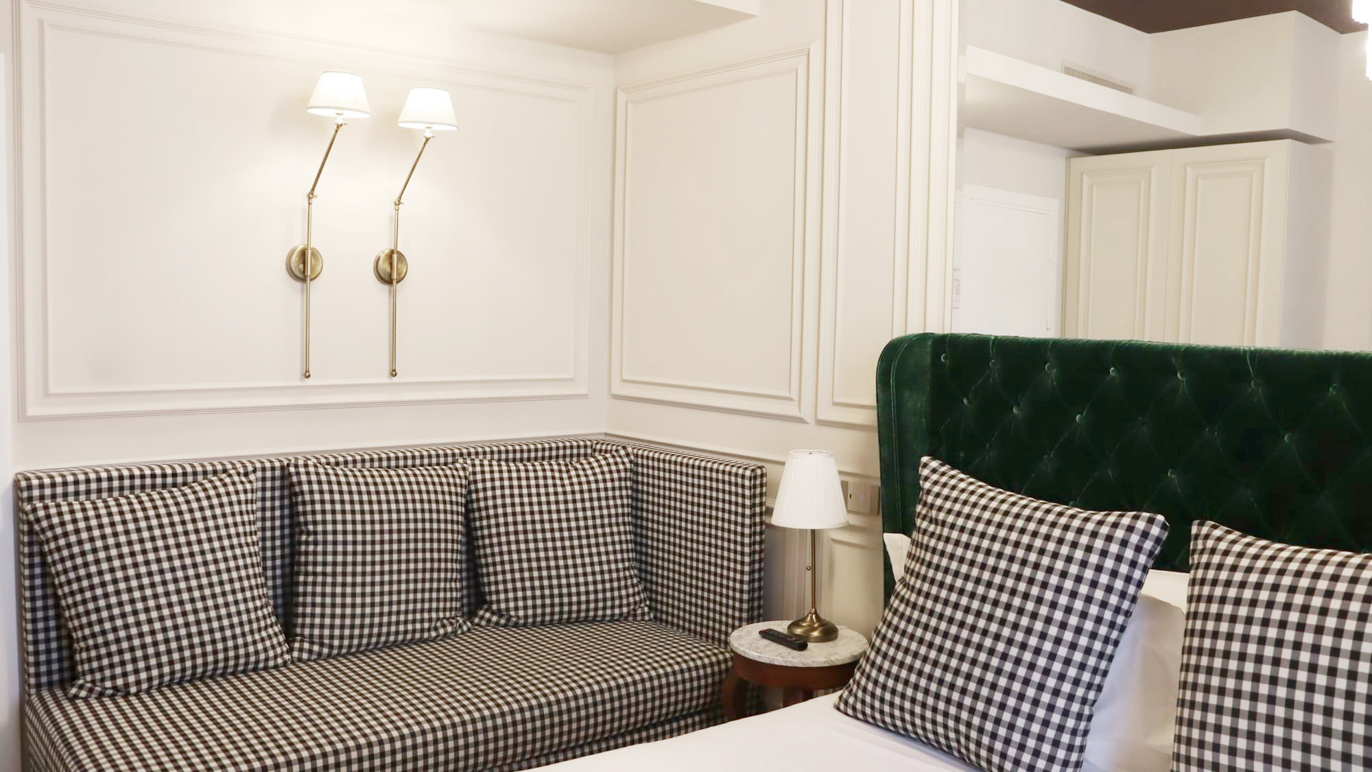 Dettaglio di uno dei letti delle camere dal Matilde Boutique Hotel, con struttura imbottita verde.