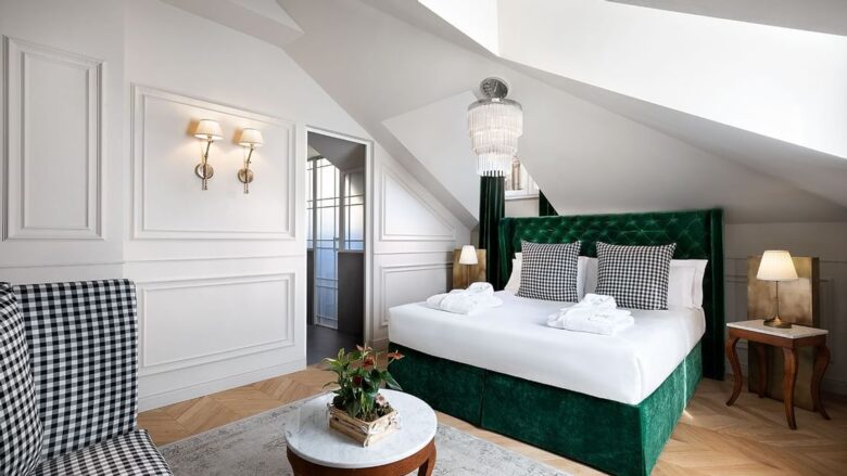 Foto di dettaglio di una delle camere del Matilde Boutique Hotel, con un divano con tessuto a scacchi e letto matrimoniale con struttura imbottita verde