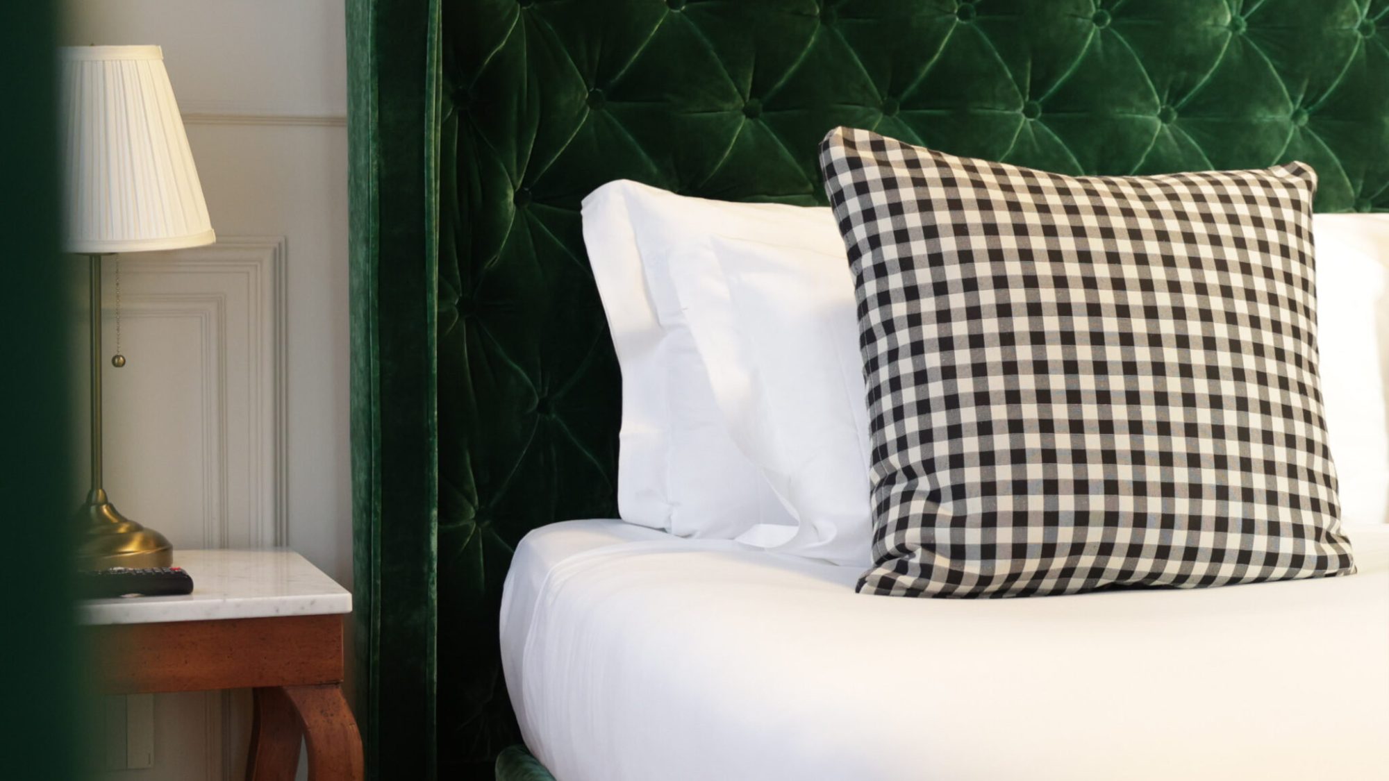 Dettaglio di uno dei letti delle camere dal Matilde Boutique Hotel, con struttura imbottita verde.